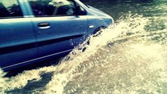 Opspattend water door voorbij rijdende auto